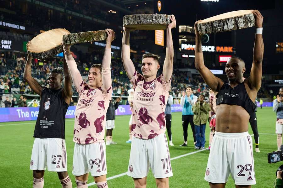 Portland Timbers' Dairon Asprilla, Nathan Fogaca, Jaroslaw Niezgoda and Juan David Mosquera lift pieces of the victory log after their 4-1 win