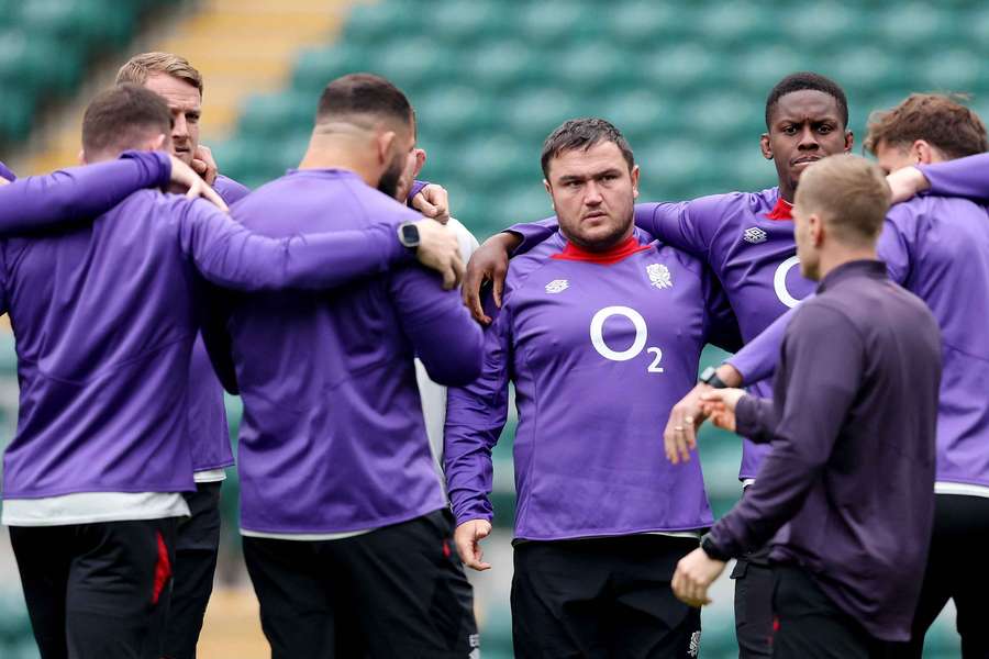 Jamie George of England looks on as players of England huddle during the England Captain's Run