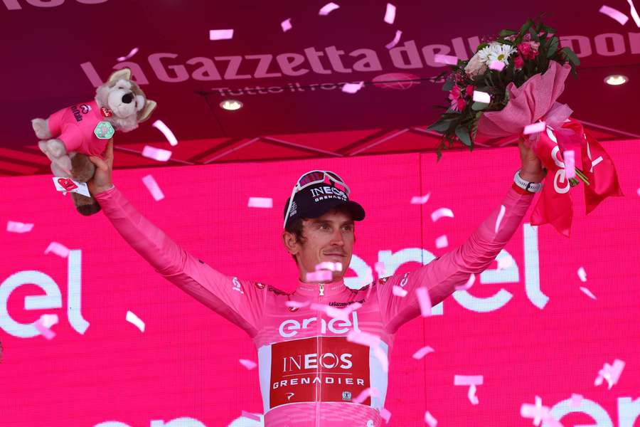 INEOS Grenadiers's British rider Geraint Thomas celebrates the overall leader's pink jersey on the podium after the seventeenth stage of the Giro d'Italia