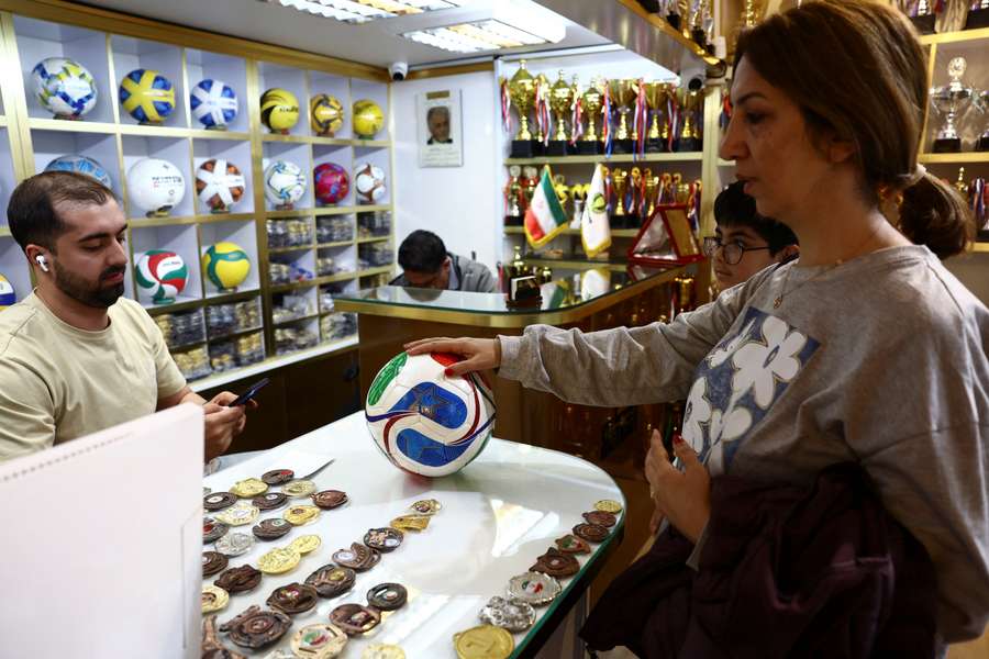 A woman buys a World Cup ball in a shop in Tehran
