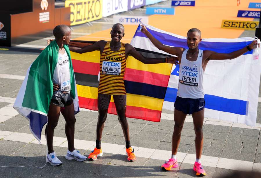 Kiplangat celebrates after winning the gold medal in men's marathon final alongside Teferi