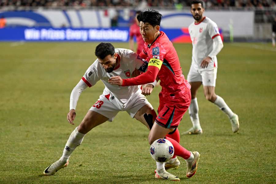 South Korea's Son Heung-min (right) fights for the ball with Jordan's Ehsan Haddad