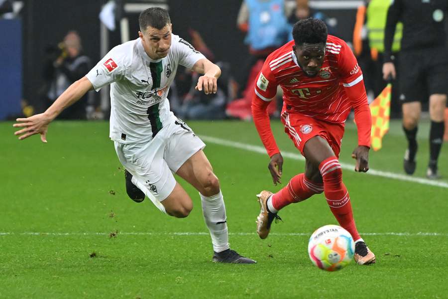 Stefan Lainer (L) in duel Bayern's Alphonso Davies