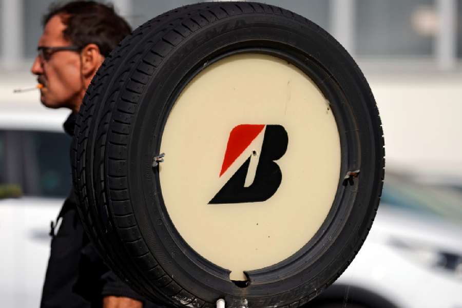 A worker walks past a tyre with Bridgestone's logo