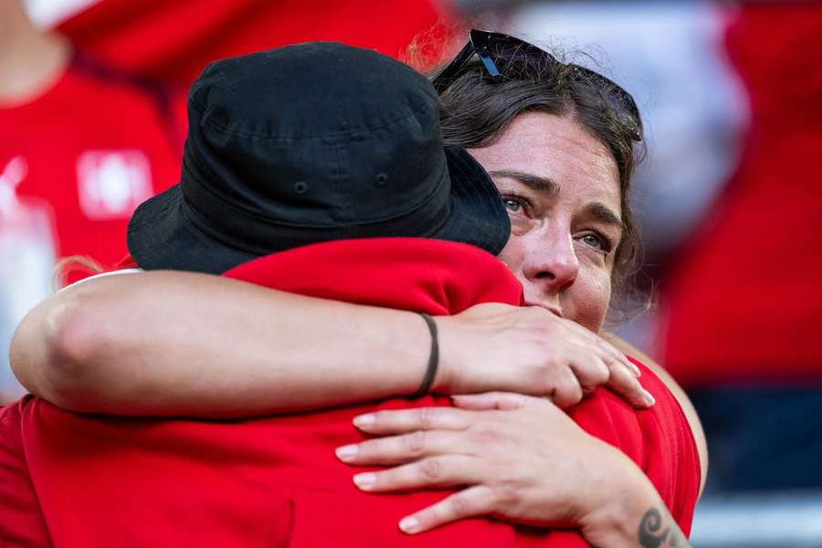 Verslagen Zwitserse supporters omhelsen elkaar na de hartbrekende nederlaag tegen Engeland.