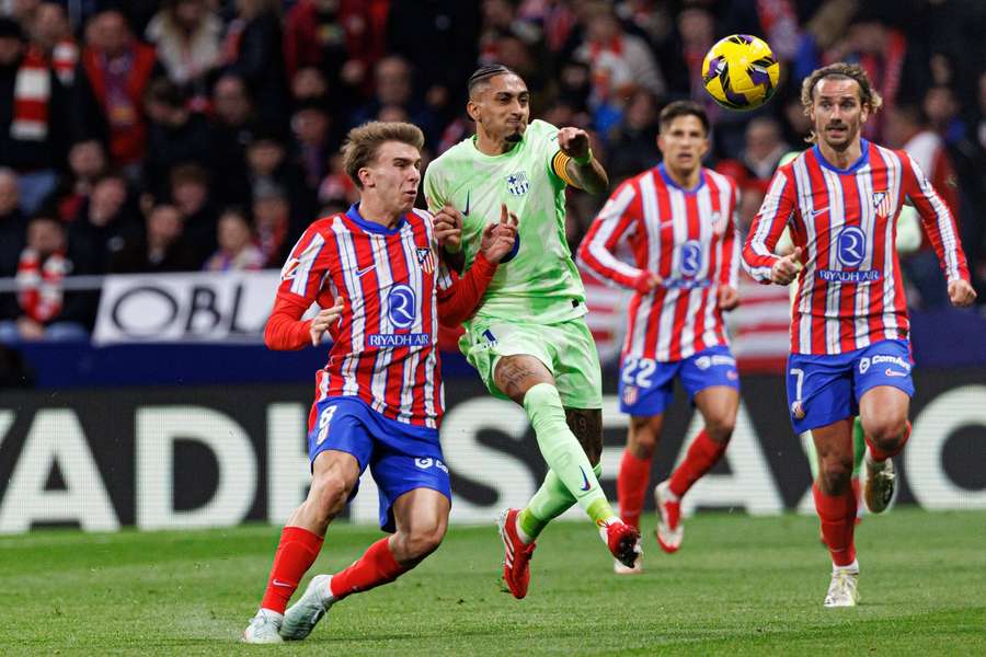 Lucas Barrios se luptă cu Raphinha în meciul din La Liga dintre Atletico Madrid și Barcelona.