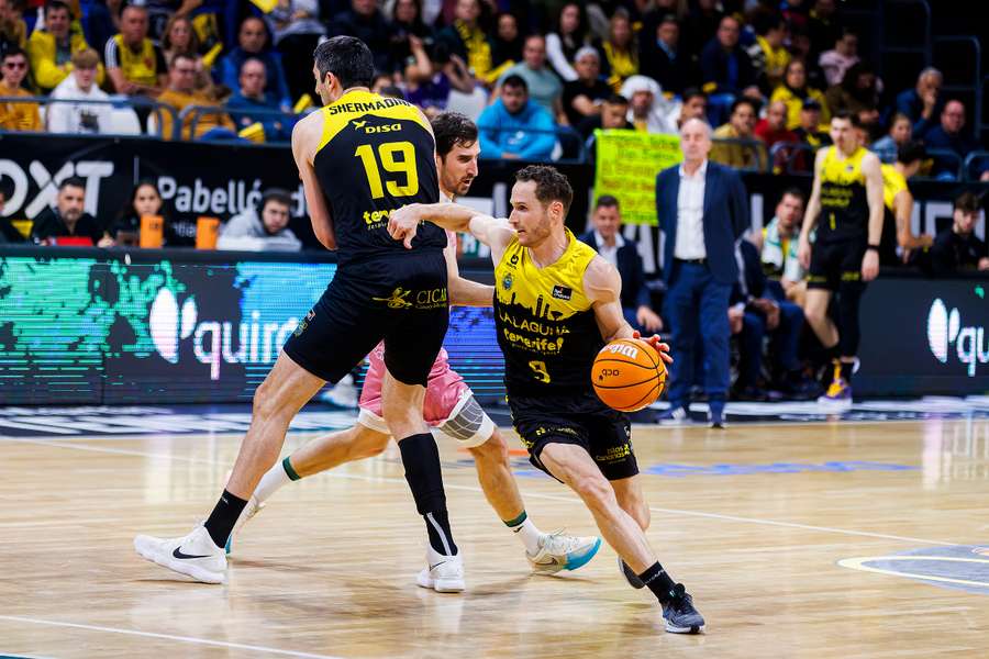 Marcelinho Huertas avanza mientras Giorgi Shermadini hace un bloqueo a Guillem Vives