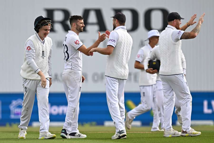 England's Mark Wood (2L) celebrates with teammates after bowling Australia's Todd Murphy