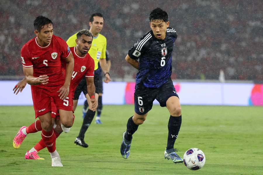 Japan's Wataru Endo in action with Indonesia's Yakob Sayuri and Indonesia's Rizky Ridho