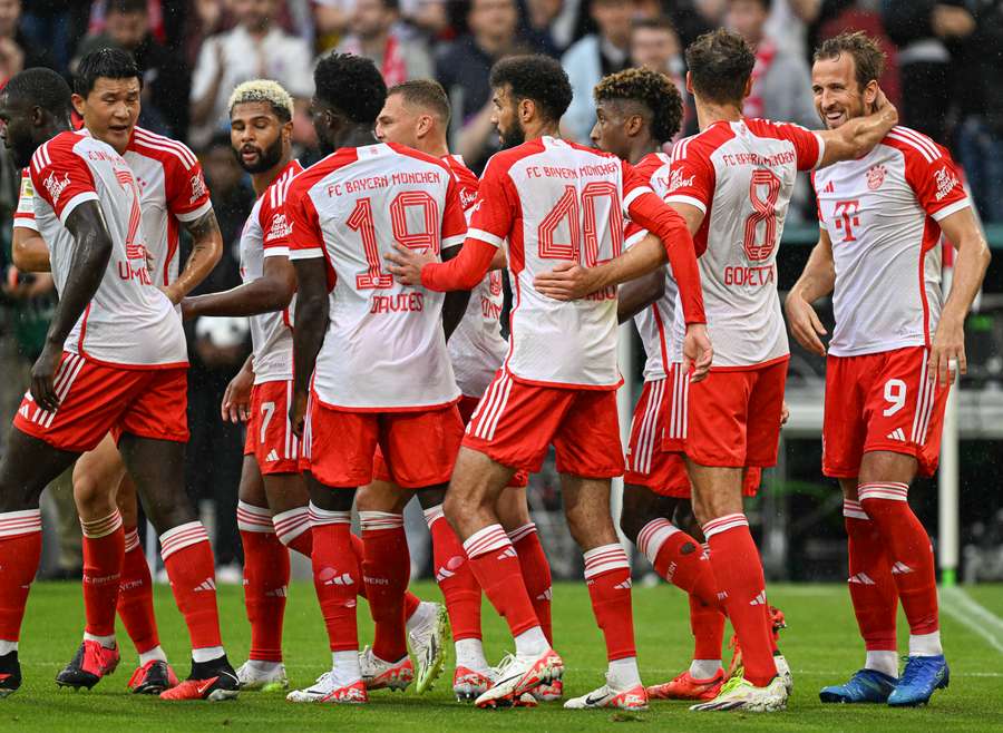 Bayern Munich forward Harry Kane (R) celebrates with teammates