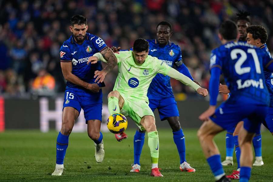 Robert Lewandowski of FC Barcelona and Omar Alderete of Getafe CF in action