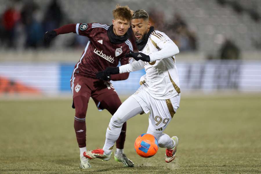 Denis Bouanga y Sam Bassett disputan un balón