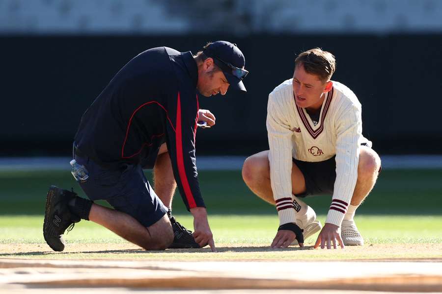 MCG head curator Matt Page and Queensland's Marnus Labuschagne inspect the pitch during a Sheffield Shield match in February. 