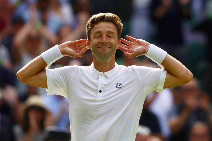 Liam Broady laps the applause of the crowd on Centre Court after his win