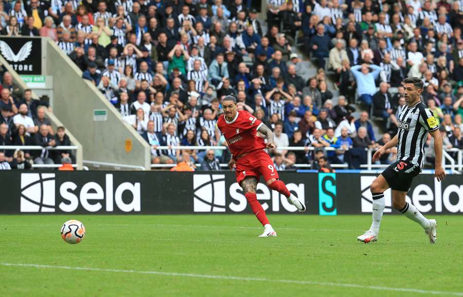 O defesa do Newcastle United, Fabian Schar (à direita), observa o avançado do Liverpool, Darwin Nunez, a marcar o golo do empate
