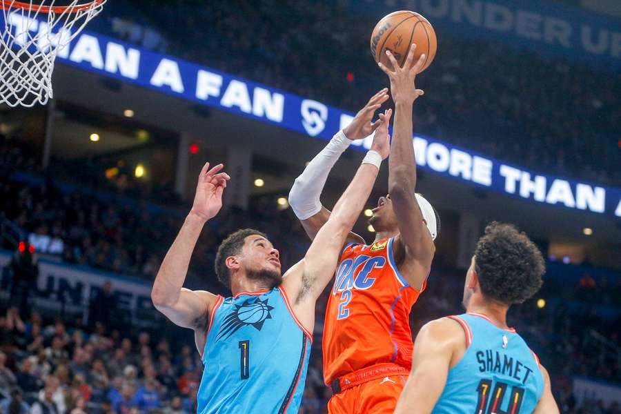 Thunders Shai Gilgeous-Alexander gaat voor een hoop terwijl Clippers' Devin Booker verdedigt