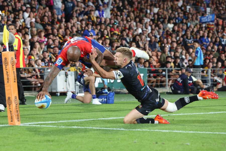 Mark Tele'a dives over the top of Damian McKenzie during a Super Rugby Pacific match earlier this year.
