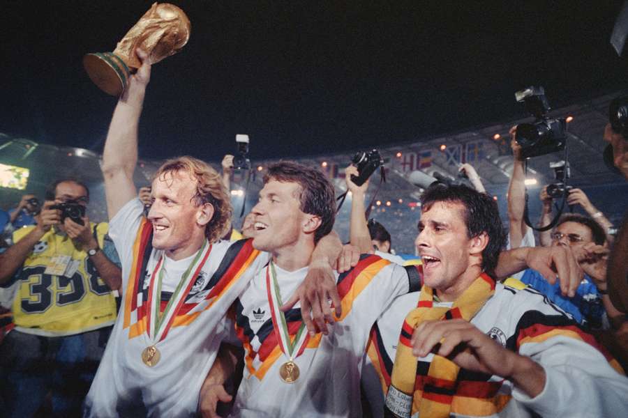 West Germany's Andreas Brehme, Lothar Matthäus, and Pierre Littbarski celebrate winning the 1990 FIFA World Cup in the iconic Adidas kit