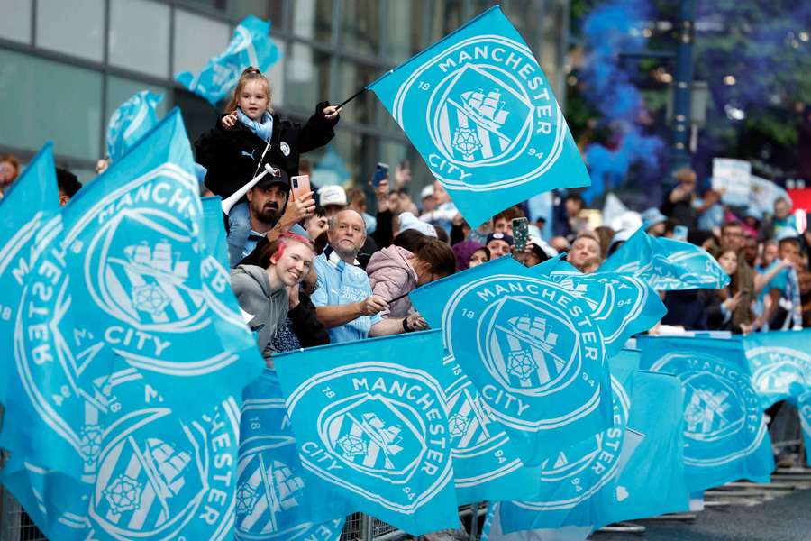 Manchester City fans welcome the players to the Etihad Stadium