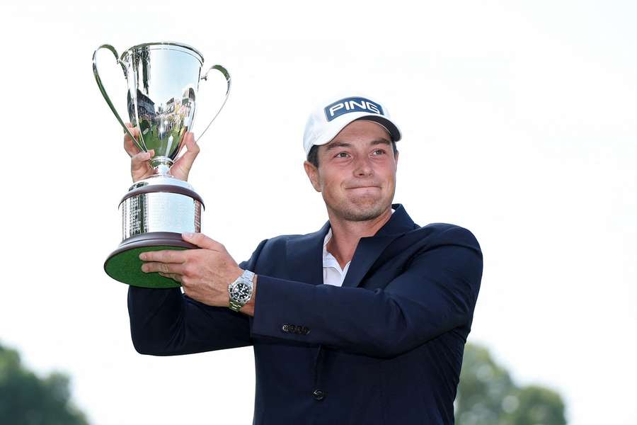 Norway's Viktor Hovland holds the trophy after winning the PGA Tour Travelers Championship over top-ranked Scottie Scheffler