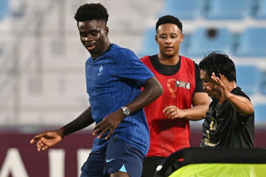 England's forward Bukayo Saka plays football with migrant workers during a meeting at the Al Wakrah Stadium in Doha 