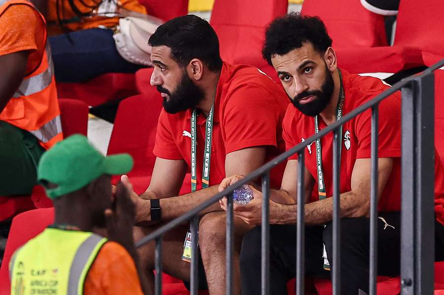 Mohamed Salah (R) privește în timp ce asistă la meciul de fotbal din grupa A a Cupei Africii pe Națiuni (CAN) 2024 dintre Guineea-Bissau și Nigeria, d