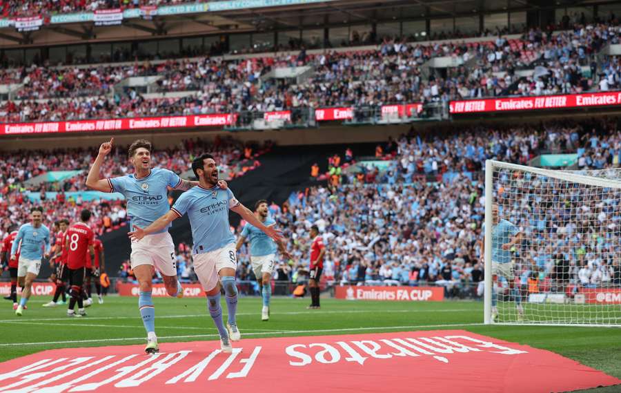 El defensa inglés del Manchester City John Stones (izq.) celebra con el goleador, el centrocampista alemán Ilkay Gundogan, tras el segundo gol.