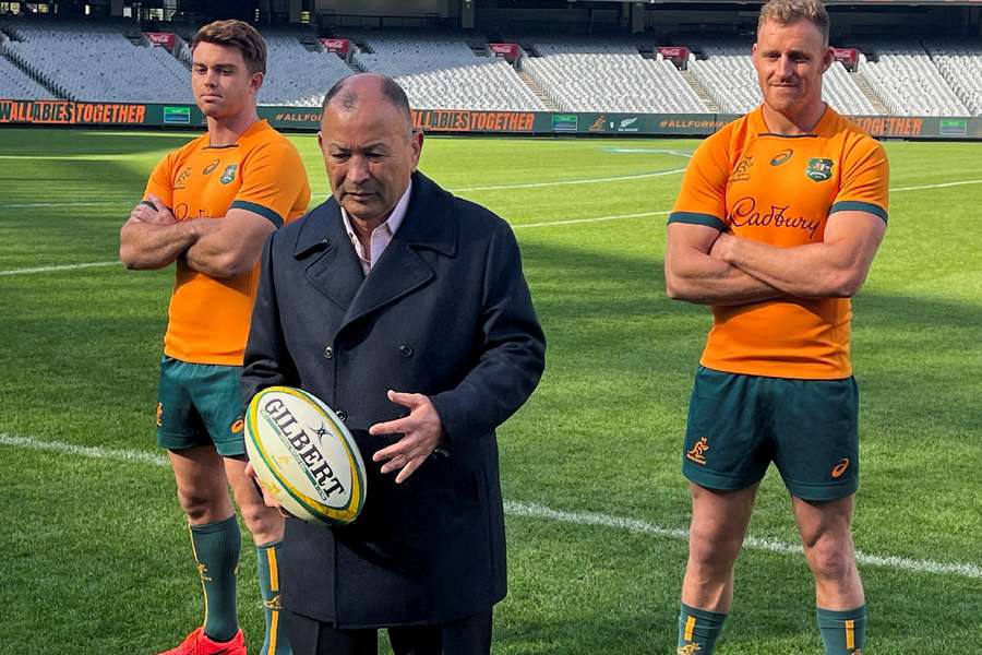 Australia rugby union coach Eddie Jones poses with a ball, flanked by Wallabies players Andrew Kellaway and Reece Hodge