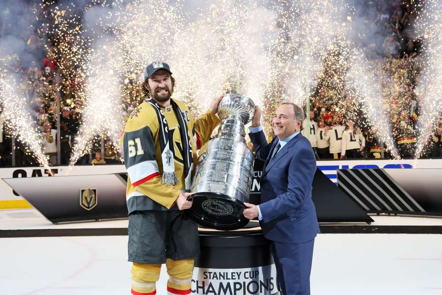 Stone avec Bettman, soulevant le trophée des champions de NHL.