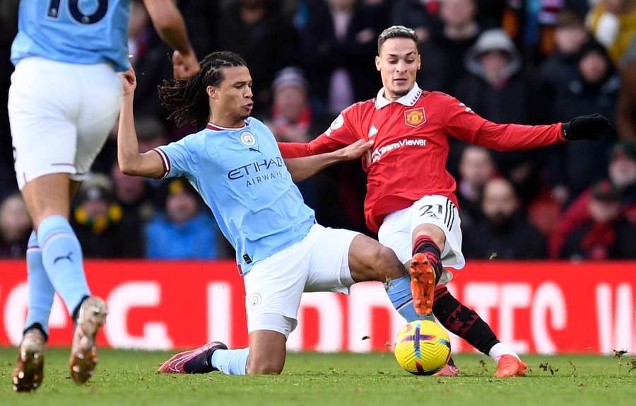 Nathan Ake challenges Antony for the ball