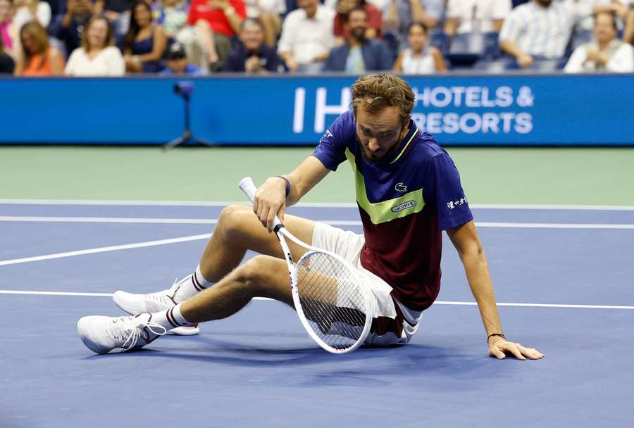 Medvedev falls to the ground during his match against Djokovic