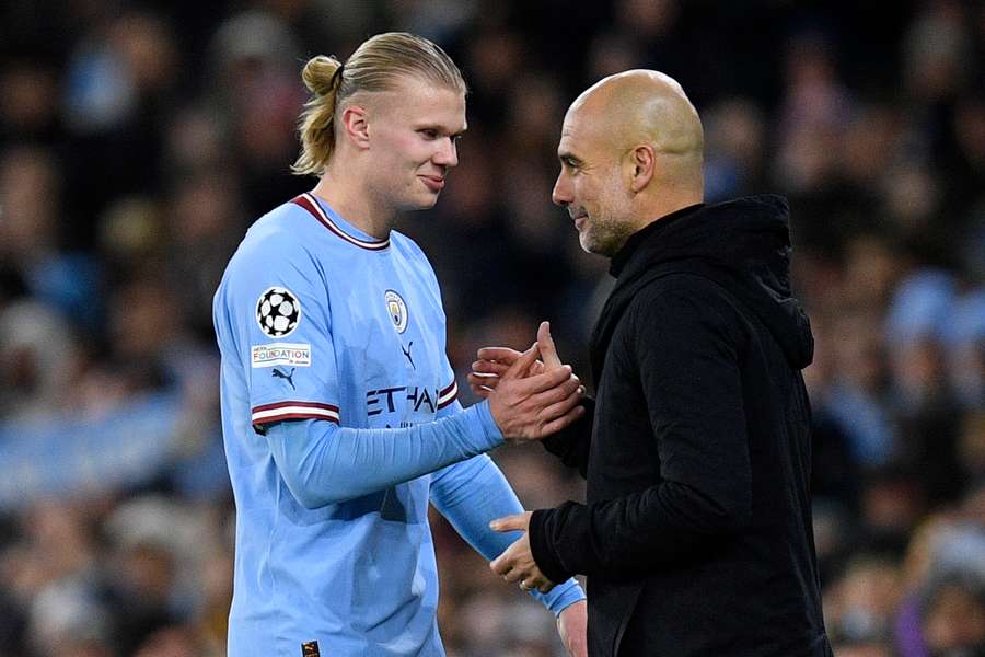 Manchester City's Norwegian striker Erling Haaland (L) shakes hands with Manchester City's Spanish manager Pep Guardiola