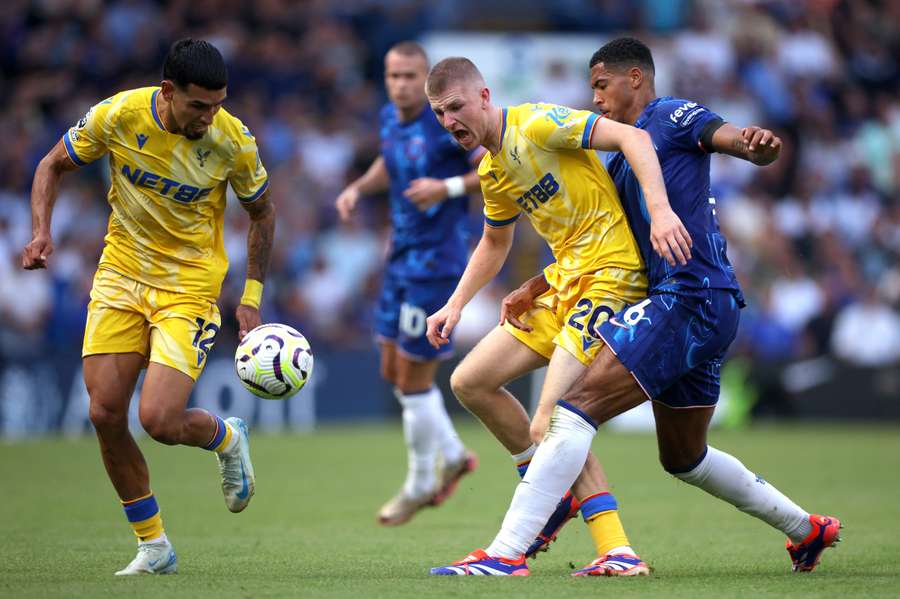 Adam Wharton of Crystal Palace is tackled by Levi Colwill of Chelsea