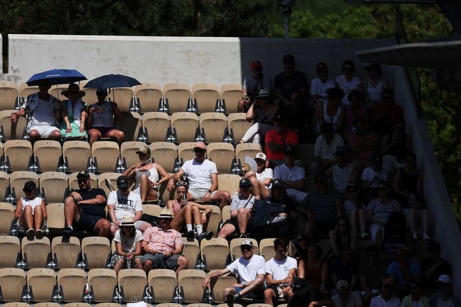 Fans auf Suzanne Lenglen schützen sich mit Schirmen vor der Sonne Fans auf Suzanne Lenglen schützen sich mit Schirmen vor der Sonne