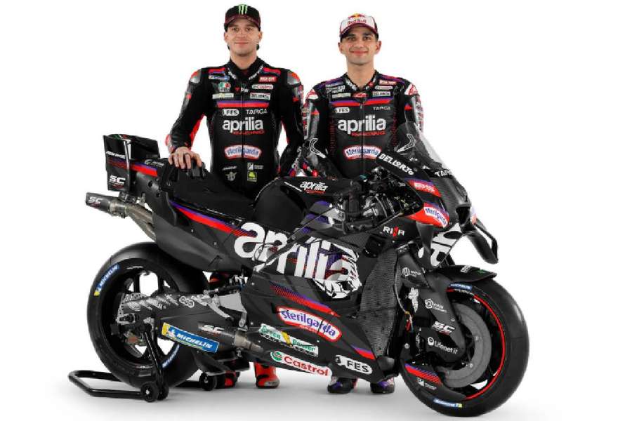 Pilotos de Aprilia posando con la moto