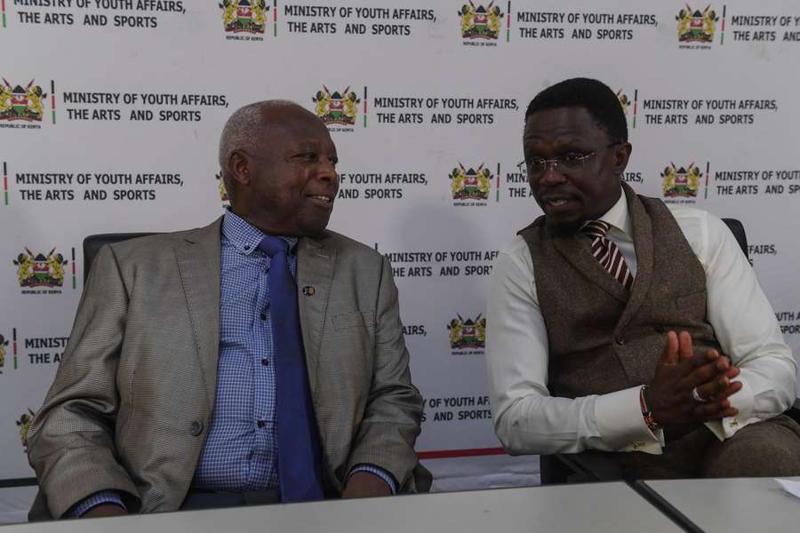 Sports Minister Ababu Namwamba (R) speaks with Athetic Kenya President Lt. General Jackson Tuwei