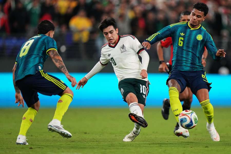 Mexico's Gilberto Mora is challenged by Colombia's Gustavo Puerta and Richard Rios