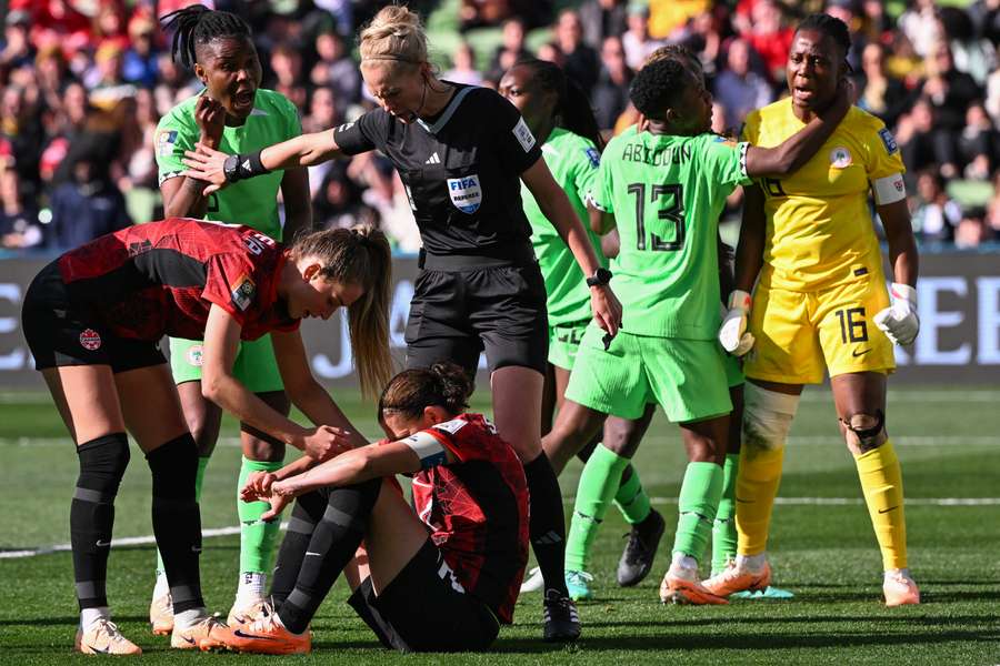 The Nigeria players (background) celebrate Canada's miss