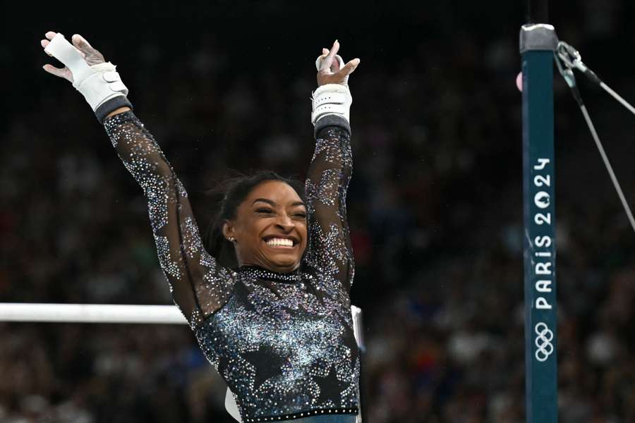 US' Simone Biles reacts after competing in the uneven bars event