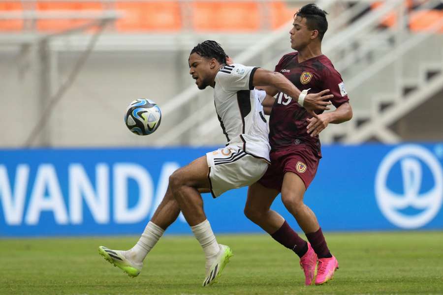 Almugera Kabar (à esq.), da Alemanha, e Junior Colina (à dir.), da Venezuela, lutam pela bola durante o Campeonato do Mundo Sub-17 da FIFA