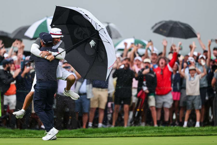 J.J. Spaun celebrates with caddie Mark Carens after winning the US Open on the 18th green