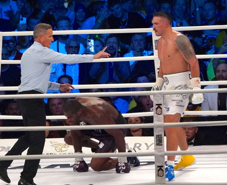 Ukraine’s reigning world heavyweight champion Oleksandr Usyk (R) waits as challenger Daniel Dubois of Great Britain (C) takes a knee