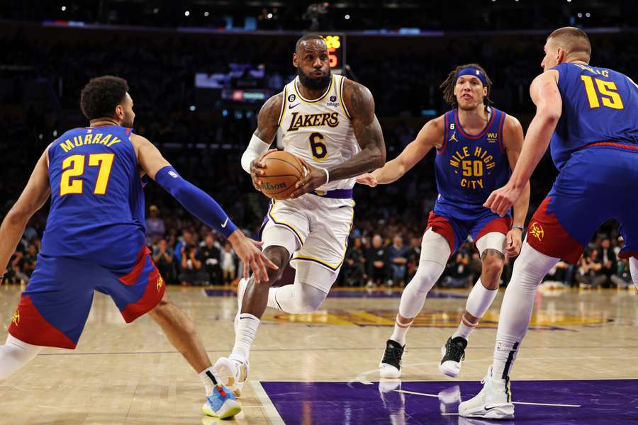 LeBron James de Los Angeles Lakers conduce hacia la canasta contra Jamal Murray, Aaron Gordon y Nikola Jokic de los Denver Nuggets.