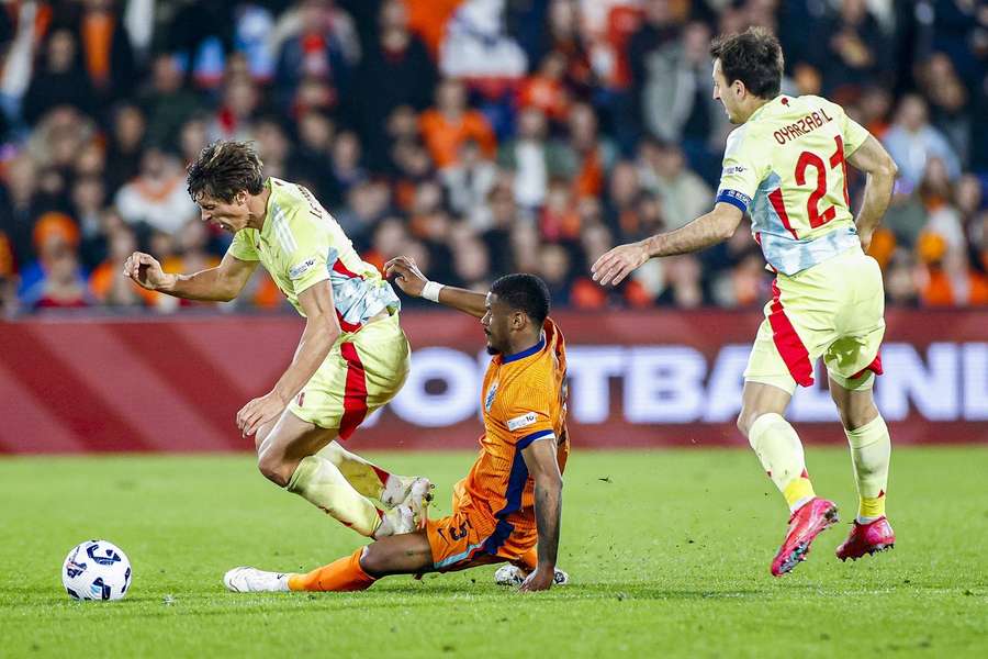 The Netherlands' Jorrel Hato commits to a late challenge on Robin Le Normand