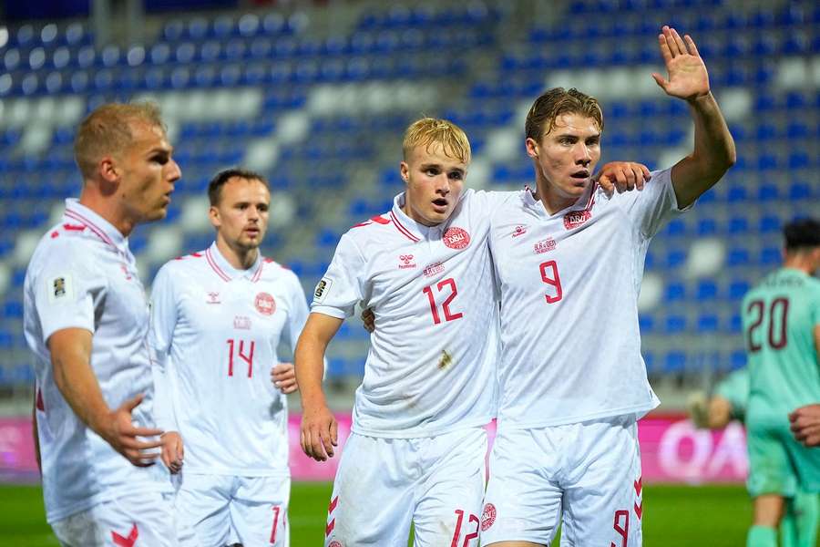 Denmark's Victor Froholdt celebrates with Gustav Isaksen, Mikkel Damsgaard, and Rasmus Hojlund after scoring Denmark's first goal