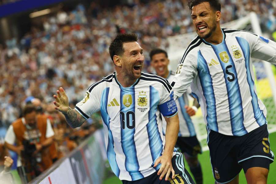 Argentina's Lionel Messi celebrates scoring their second goal with Leandro Paredes