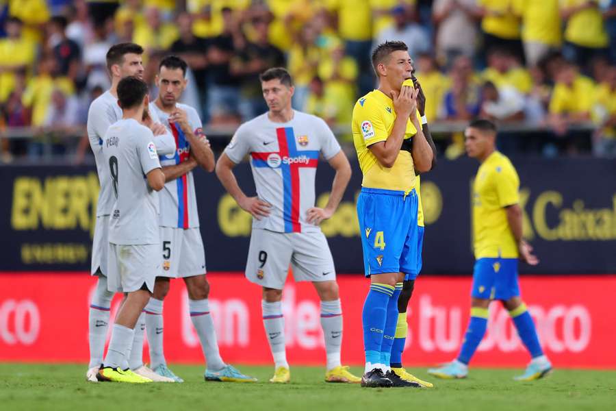 Both sets of players watch on as a Cadiz fan receives medical attention in the stands