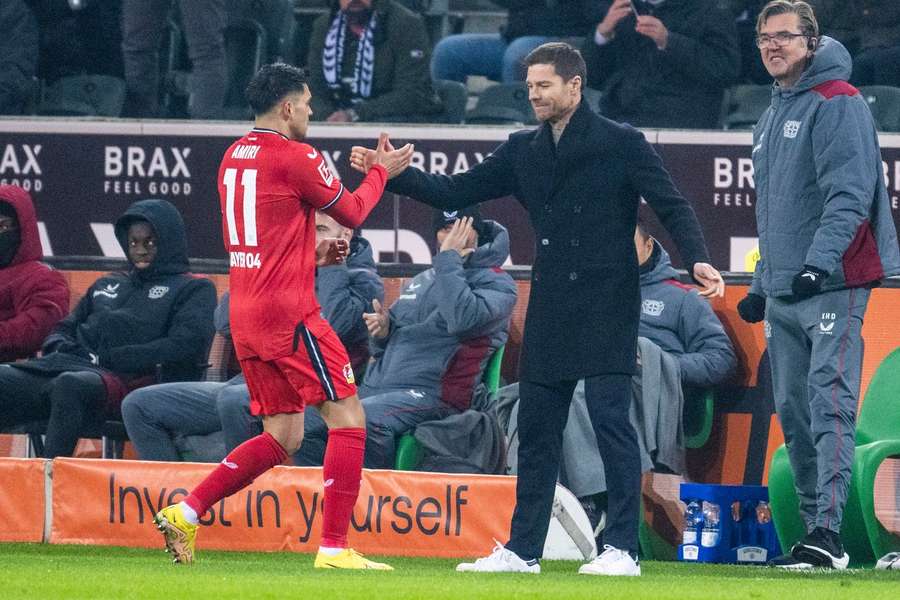 Xavi Alonso saluda a Amiri durante un partido del Bayer Leverkusen.