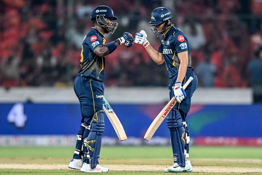 Gujarat Titans' Sherfane Rutherford (L) and captain Shubman Gill bump their fists