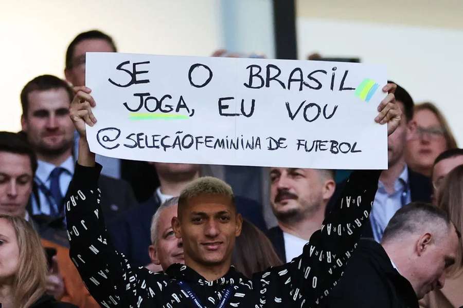 Richarlison em Wembley com o cartaz de apoio à seleção feminina do Brasil